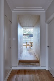 Spatial interconnectivity is facilitated through a plywood "chute" that connects and delineates the original house from the new addition.