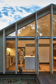Floor-to-ceiling glass windows with sliding glass doors allow access to the decked outdoor space. Because the area is covered by the roof's overhang, the family can enjoy the new bright and airy environment, no matter the weather. 
