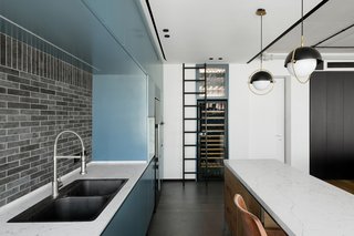 The black and white color scheme uses a cool share of teal as an accent color in the kitchen.