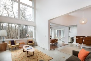 An Eco-Friendly Connecticut Home Wants $650K - Photo 3 of 10 - The open layout on the main level includes the living room with a fireplace, the dining room, and the kitchen. 