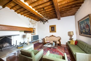 You Can Own Michelangelo’s Former Tuscan Villa For $9.3M - Photo 6 of 11 - Beamed ceilings, along with another grand fireplace, are the focal points of this sitting room.