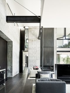 This Concrete Abode Stretches Over Giant Boulders - Photo 6 of 17 - The interior also features a layering of space that can be seen here in the living room. 