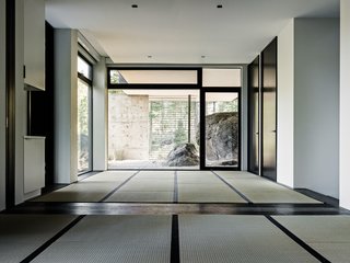 This Concrete Abode Stretches Over Giant Boulders - Photo 9 of 17 - A sense of Japanese minimalist design permeates the home. Tatami mats are now used in a space that leads out to a very zen-like rock garden. 
