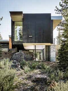This Concrete Abode Stretches Over Giant Boulders - Photo 1 of 17 - Throughout the site, the original boulders that have been left untouched are evident as the home engulfs them into its design. 