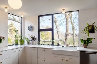 A Renovated Farmhouse in the Hamptons Hits the Market at $2.8M - Photo 7 of 13 - The kitchen offers plenty of storage and windows which offer plenty of natural light.
