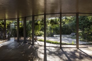 A Modern Concrete Retreat by Oscar Niemeyer Is Available For the First Time - Photo 1 of 6 - The main living space opens to a lush, tropical garden, creating a seamless integration between the home and its natural environment. 