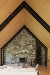 A Minimalist, Rick Joy–Designed Farmhouse in Vermont Asks $9.25M - Photo 6 of 12 - The use of stone carries over into the interiors to create a rustic, elegant, wood-burning fireplace. 