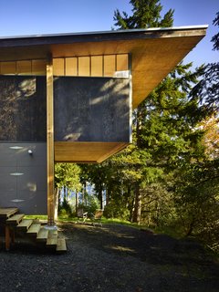 Reclaimed Materials Make Up This Artist Studio in Washington - Photo 1 of 6 - The home's minimalist construction includes a mix of unfinished and charred plywood to form a simple, two-story volume with a slightly sloping roof and a cantilevered bedroom loft with clerestory windows made from polycarbonate panels. 