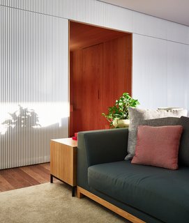 The white wood panel adds texture and depth to the home, and contrasts beautifully with the wood-clad hallway that leads to the bedrooms. 