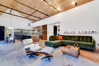 Own This Alluring Sculptural Abode in Austin For $3.1M - Photo 1 of 21 - The property is comprised of three distinct sculptural volumes. The simplified and abstracted white stucco forms and curvilinear roofs create a distinct composition within the landscape. In contrast, bold, tactile materials define the interiors. The home features an open plan kitchen, dining area, and living room, which all house wide plank hickory pecan floors and ceilings. 