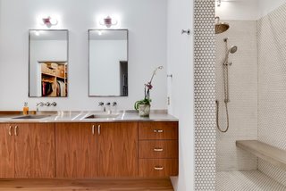 Own This Alluring Sculptural Abode in Austin For $3.1M - Photo 9 of 21 - The home features four-and-a-half baths. The one above has two sinks and a stylish penny-tile shower. 
