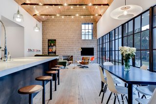 Own This Alluring Sculptural Abode in Austin For $3.1M - Photo 3 of 21 - The craftsmanship integral to the experience of the house is evident in the welds of the custom steel windows, the tool marks of the waxed hot-rolled steel panel at the kitchen island, and the hand-turned walnut seats of the bar stools. 