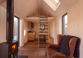 Go Off-Grid in This Prefabricated Cor-Ten Steel Cabin - Photo 8 of 12 - The compact interior space measures 129 square feet, with a built-in bed and space for a kitchenette, table, bench, shelves, and stove. The addition of a skylight helps keep the interiors bright. 