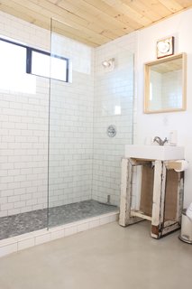 A glass-enclosed shower helps increase the sense of space in the tiny bathroom. 
