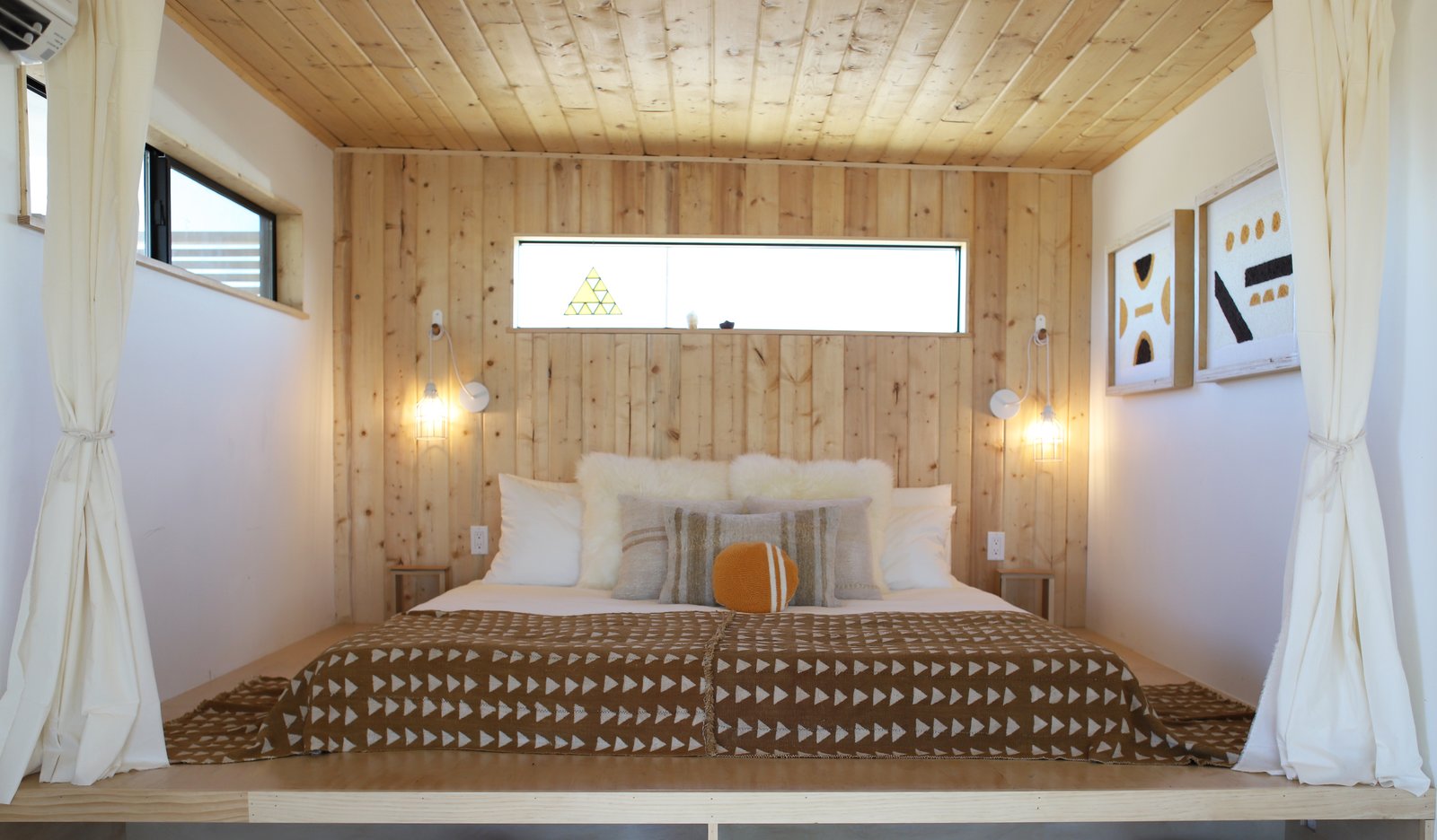 Wood paneling and a platform bed was a perfect solution for fitting a king-sized bed into a small space.