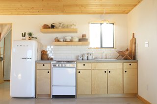 For the petite open kitchen, the Smirkes designed the cabinets and had the boxes and doors made at a small cabinet shop in L.A. They also formed and poured the concrete countertops themselves and constructed the floating shelves with leftover clear pine and plywood. 