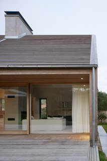 Sliding glass doors allow the kitchen and living room to be fully opened to the deck, creating a seamless integration between the interior and exterior space.