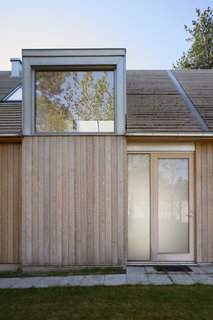 The light-colored larch and expanses of glass provide the home with a natural vibe, while also helping to integrate it into its sylvan setting. 