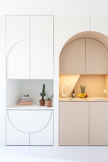 The redesign includes bespoke cabinetry which conceals a hidden dining table and stools, as well as a small fridge.