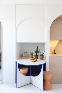 The tiny table with two stools pops out from the cabinetry.