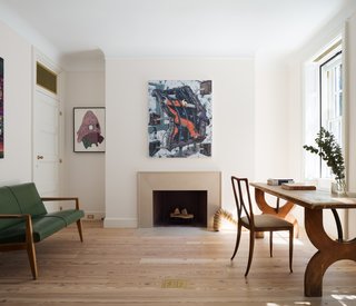 The focal point of the study is a custom-designed limestone fireplace and the artwork above it. 