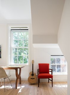 The study is punctuated by a red accent chair. 