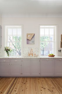 The custom millwork was painted Farrow & Ball Calluna No. 270, which is described as a tranquil lilac and looks light gray according to the light. 