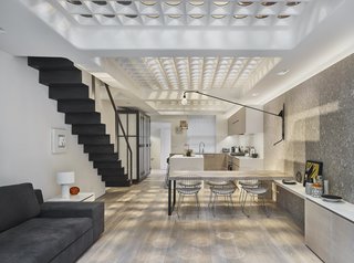 The dappled light brightens the basement which houses the kitchen and an open-plan living and dining area.