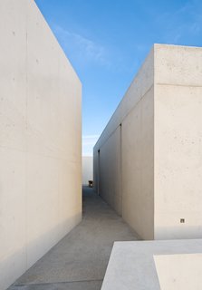 The entire house is full of immersive moments. From the corridors, the concrete walls create shallow view-angles that reveal glimpses of each subsequent space and simultaneously frame the bright blue sky above. 