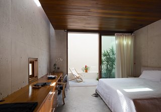 Even the bedrooms integrate the outdoor spaces into the design. Here, a guest room opens to a small terrace. 
