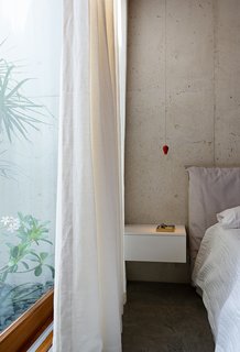 A pendant lights hang like flower buds from the ceiling, and long fronds peek in from the adjacent rock-bottomed gardens. 
