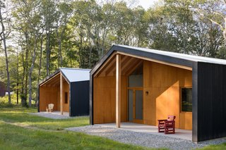 The dark stained cedar exteriors and galvanized metal roofs house bright, warm interiors. 