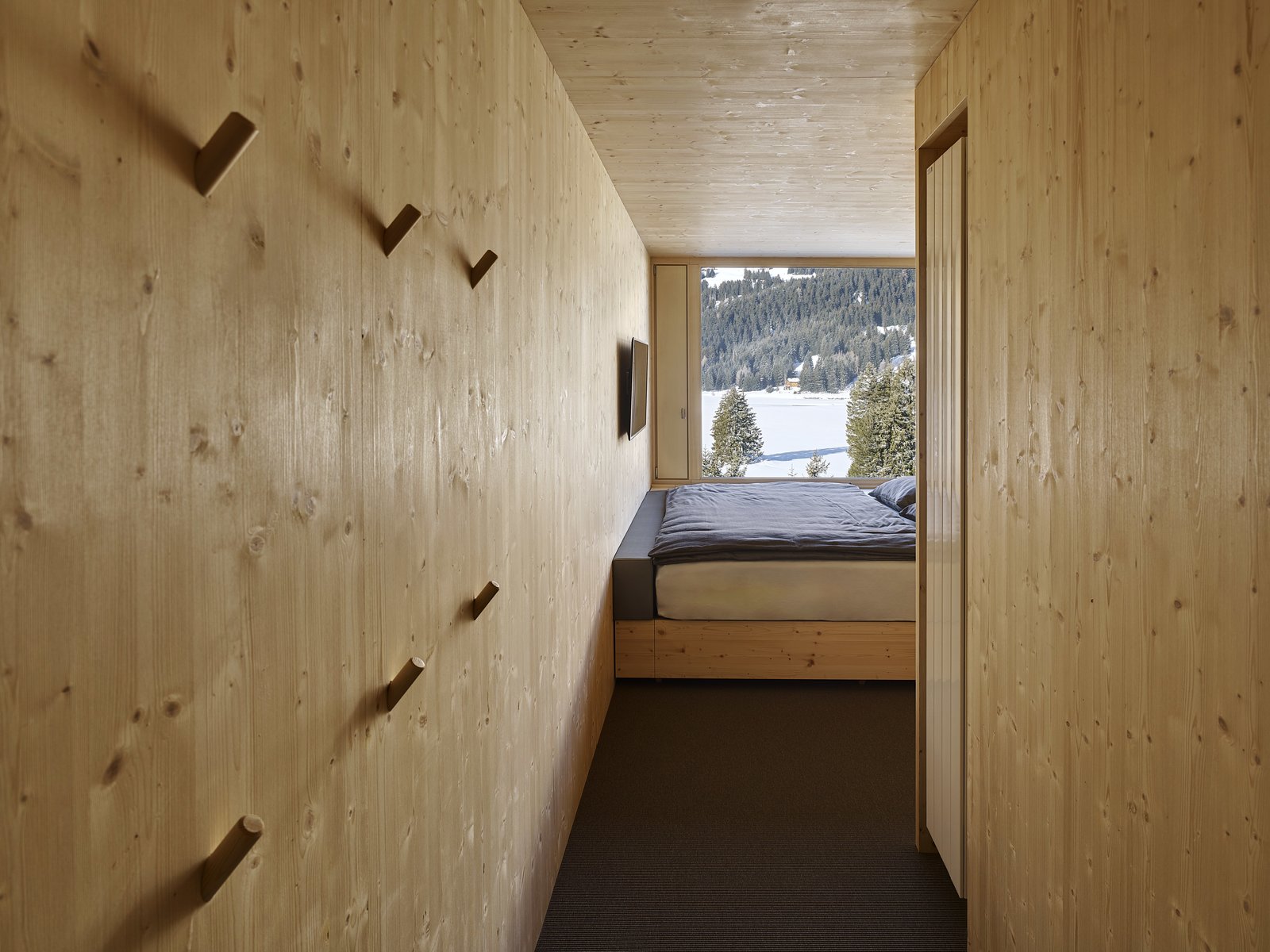 The ceilings, floors, and walls of the rooms are constructed from natural, unfinished plywood.