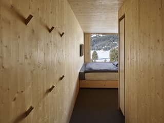 The ceilings, floors, and walls of the rooms are constructed from natural, unfinished plywood. 