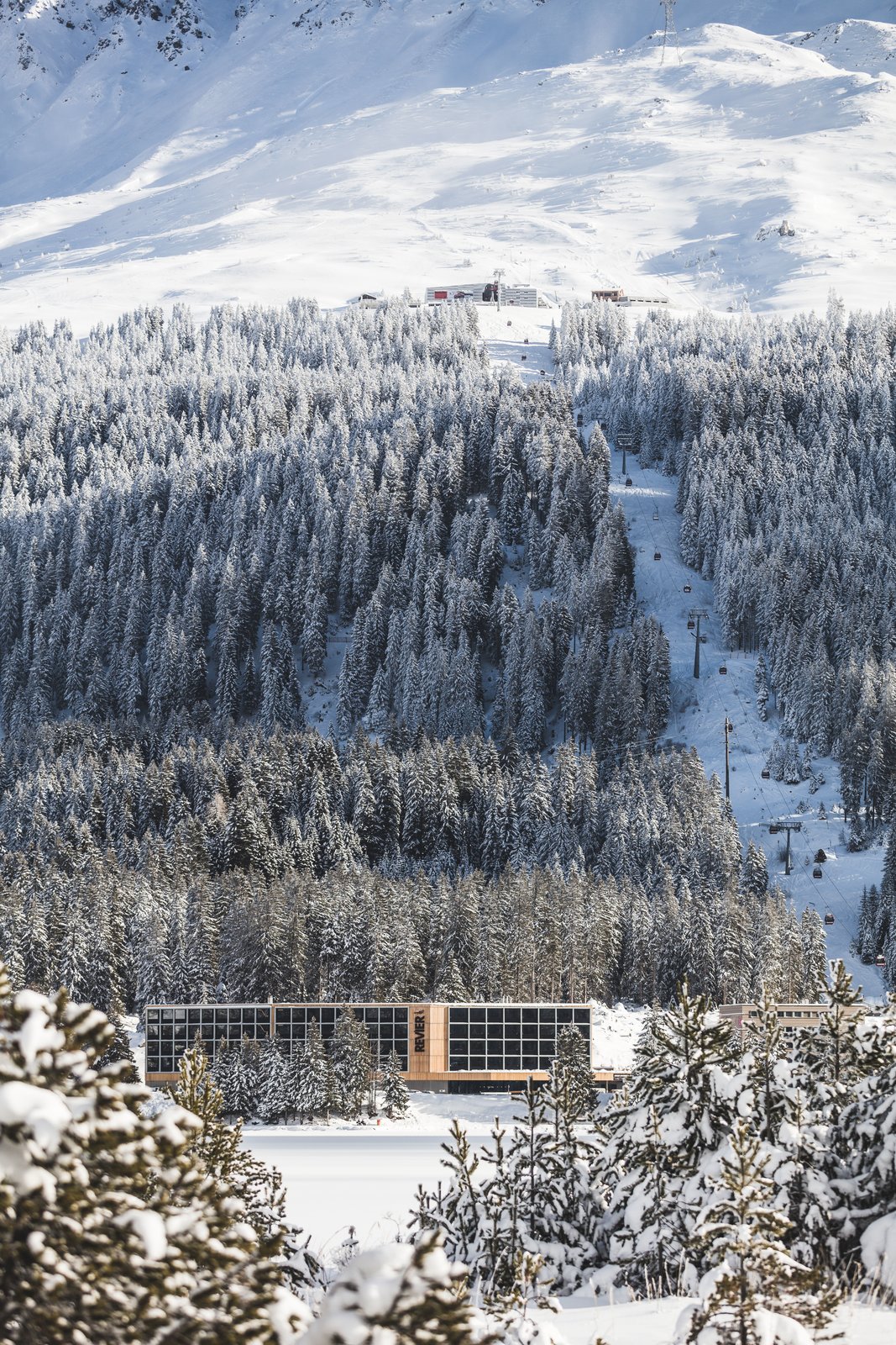 The modern ski chalet in its snowy alpine setting.