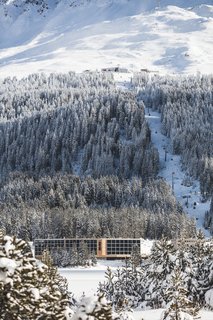 The modern ski chalet in its snowy alpine setting.