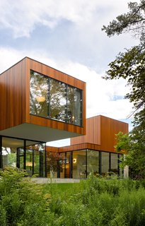 An L-shaped configuration organizes the ground-floor spaces. The volume that accommodates the grandparents' suite contains a kitchenette, a bedroom, and a private bathroom.