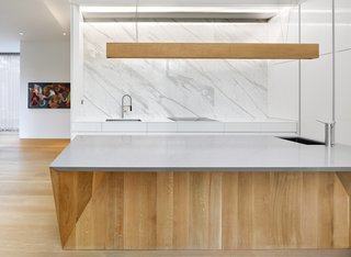 Calacatta marble slabs are meticulously detailed to reflect the surrounding landscape and contrast the heavy, flat-sawn solid oak island with a faceted base. 