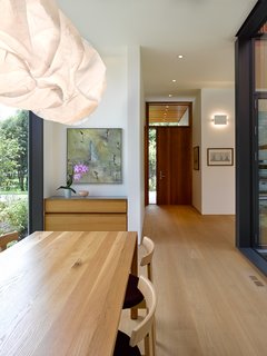 The dining room serves as the main shared social space between the two volumes. With glazed expanses on either side, the landscape flows from the creek, through the courtyard, and to the front of the house. 