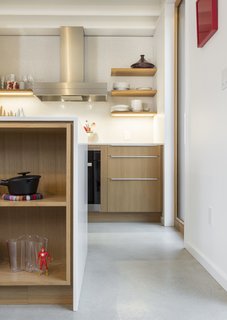 The kitchen features white quartz counters, a mounted induction cooktop, and a full-height backsplash with white penny-round tiles. 