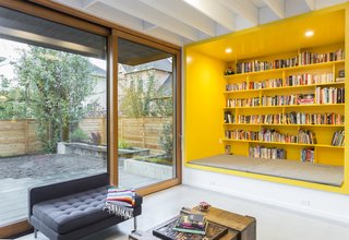 A floor-to-ceiling sliding door offers direct access to the patio and yard. A yellow custom-built reading nook packs a playful punch of bold color, and certainly brightens up the gray days that the Pacific Northwest is known for. 