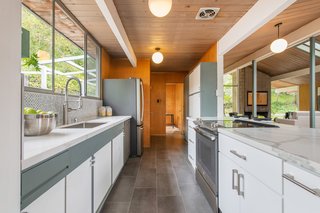 Tasteful contemporary updates have been added, including a renovated kitchen with composite countertops, stainless steel appliances, a new electric cooktop, new tile backsplash, and ample cabinet space. 