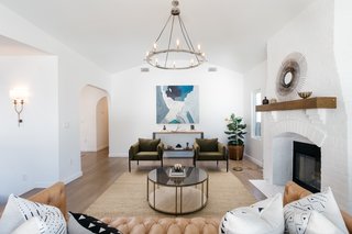 The living room also offers new lighting from Restoration Hardware, a decorative fireplace, and newly installed wide-plank oak floors.