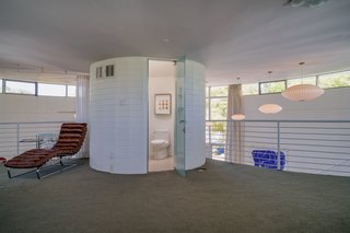 A distinct cylindrical volume encloses a bathroom that echoes the design of the home. 