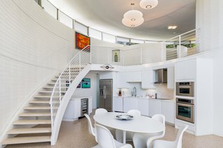 The open layout includes a staircase leading to the second loft-like level. 