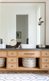 The bunk room bathroom was designed to be used by multiple people at the same time. The tiles are from Commune Design, and the wall sconces are from Schoolhouse Electric. 