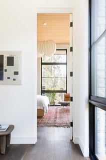 The master suite is on the ground floor and accessed via a home office. The pendant light over the bed is a commissioned custom fabrication by Stephen White made from dowels and rice paper. "We didn’t know exactly what we were going to get until it arrived," explained Haines, "but it is spectacular."