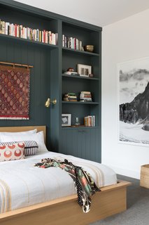 The guest bedroom features custom, built-in shelving over the bed designed by ABD Studio. The bedding is a mix of vintage pillows with Coyuchi. The black and white photograph is from Olivo Barbieri. 