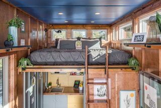 The sleeping loft is accessed via a library ladder, with clerestory windows added to keep the space from feeling too claustrophobic. 