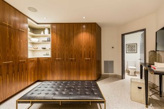 One of the walk-in closets features walnut cabinetry.